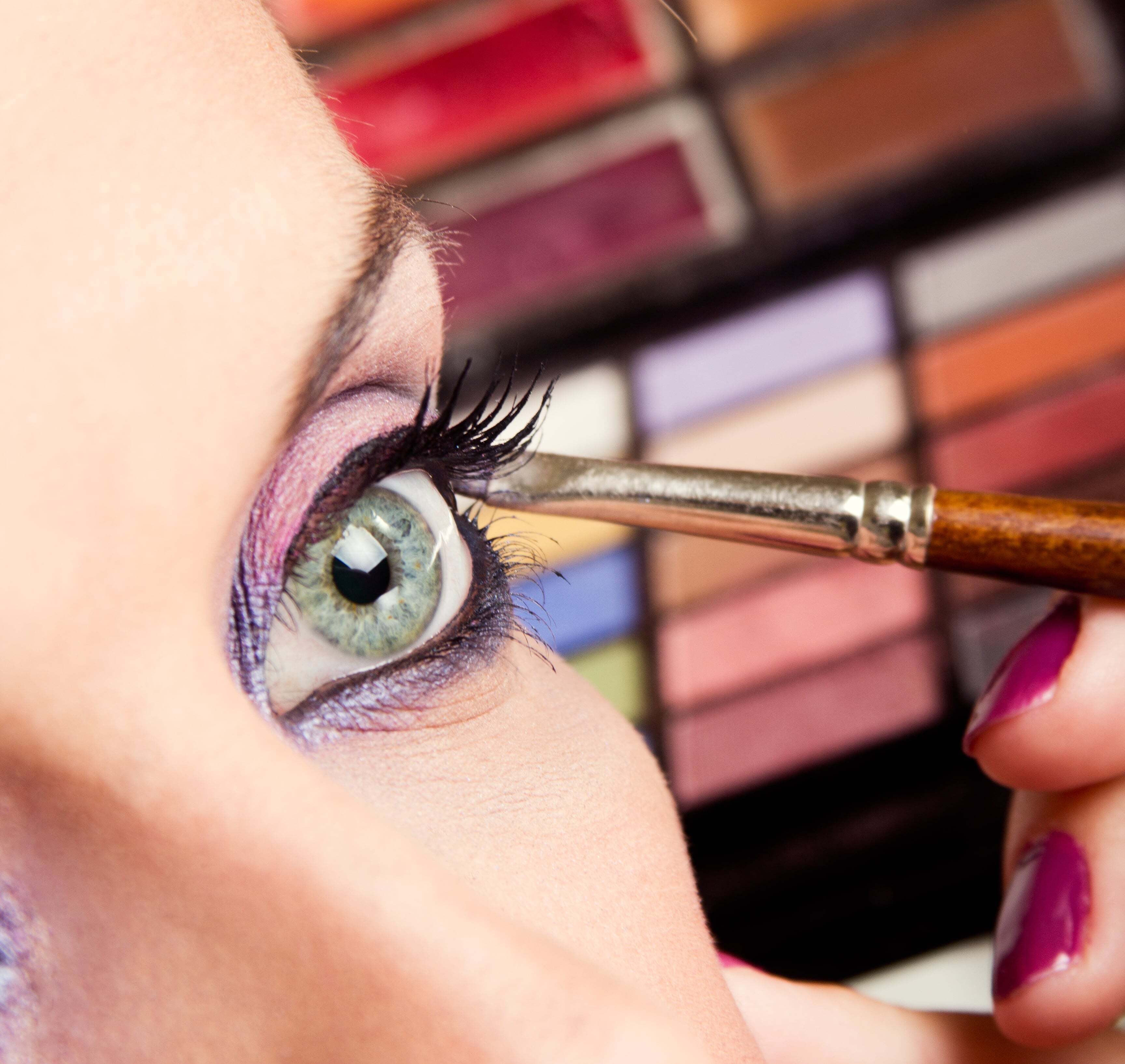 Profesionalni makeup artist applying false eyelashes with precision